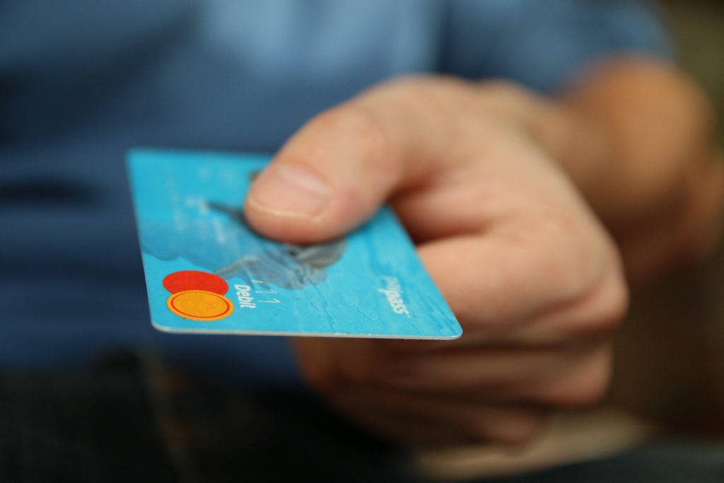 Image of a person holding a debit card
